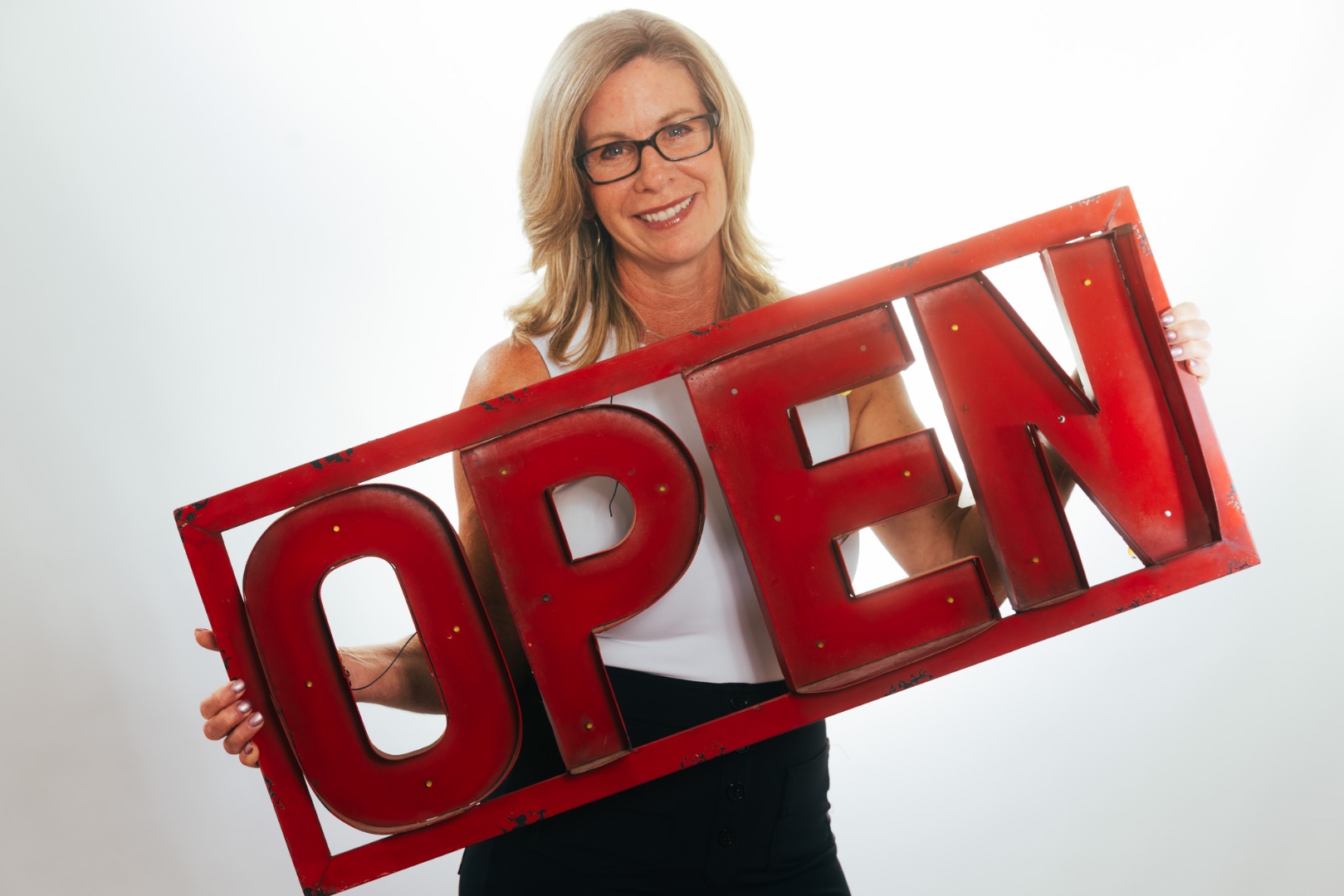 Tracey Dixon studio headshot with vintage OPEN marquee sign — The Dixon Team